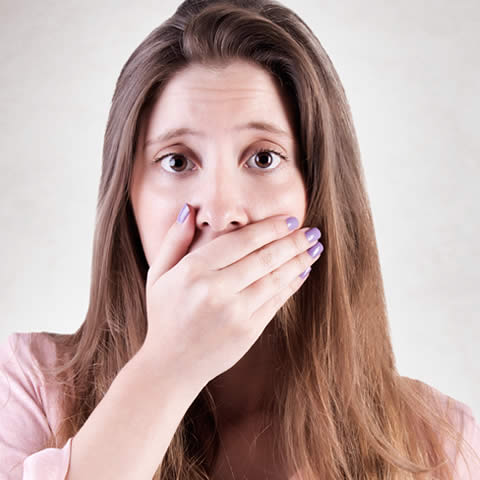 Lady holds hand over her mouth in shock.